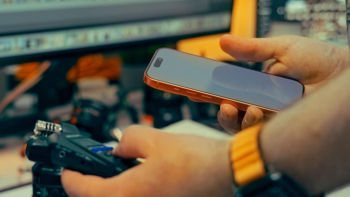 A person interacts with a smartphone and camera in an indoor studio environment. Perfect for media and production themes.