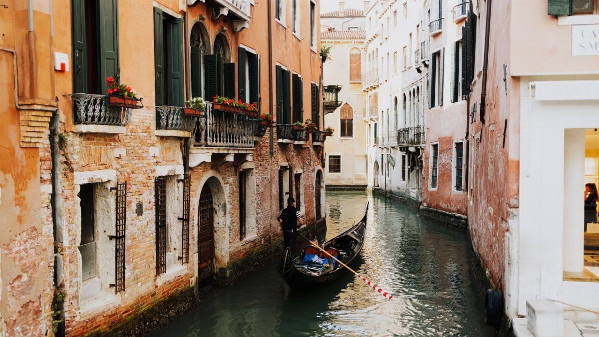 Picturesque view of a gondola on a narrow canal in Venice, Italy, surrounded by charming buildings.