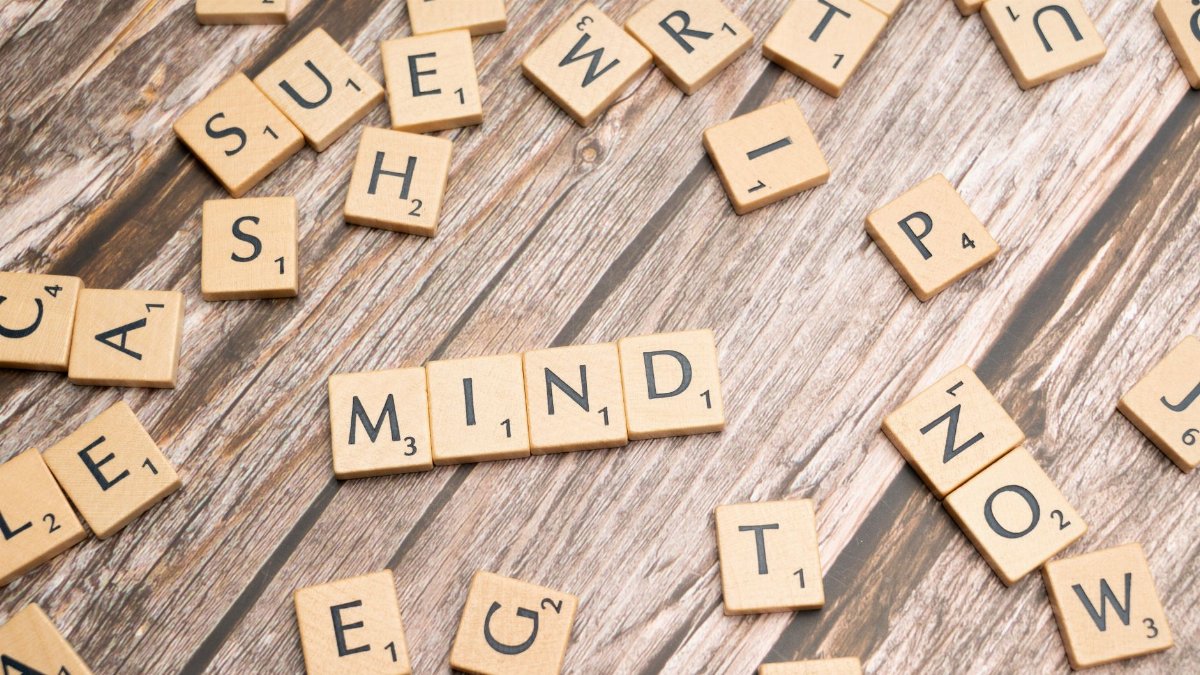 Scattered wooden letter tiles on a rustic wood surface highlighting the word 'Mind'. Ideal for mental and cognitive themes.