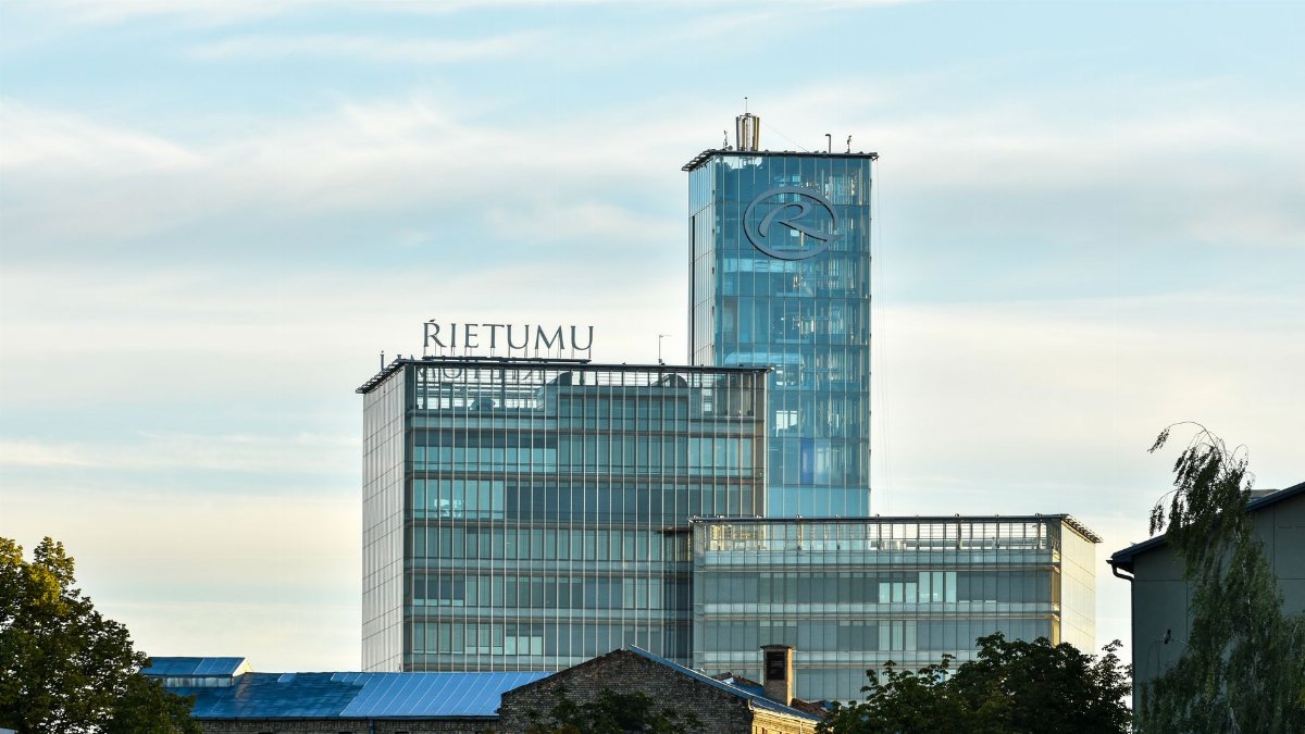 The sleek architecture of the Rietumu Bank building against a summer sky in Riga, Latvia.