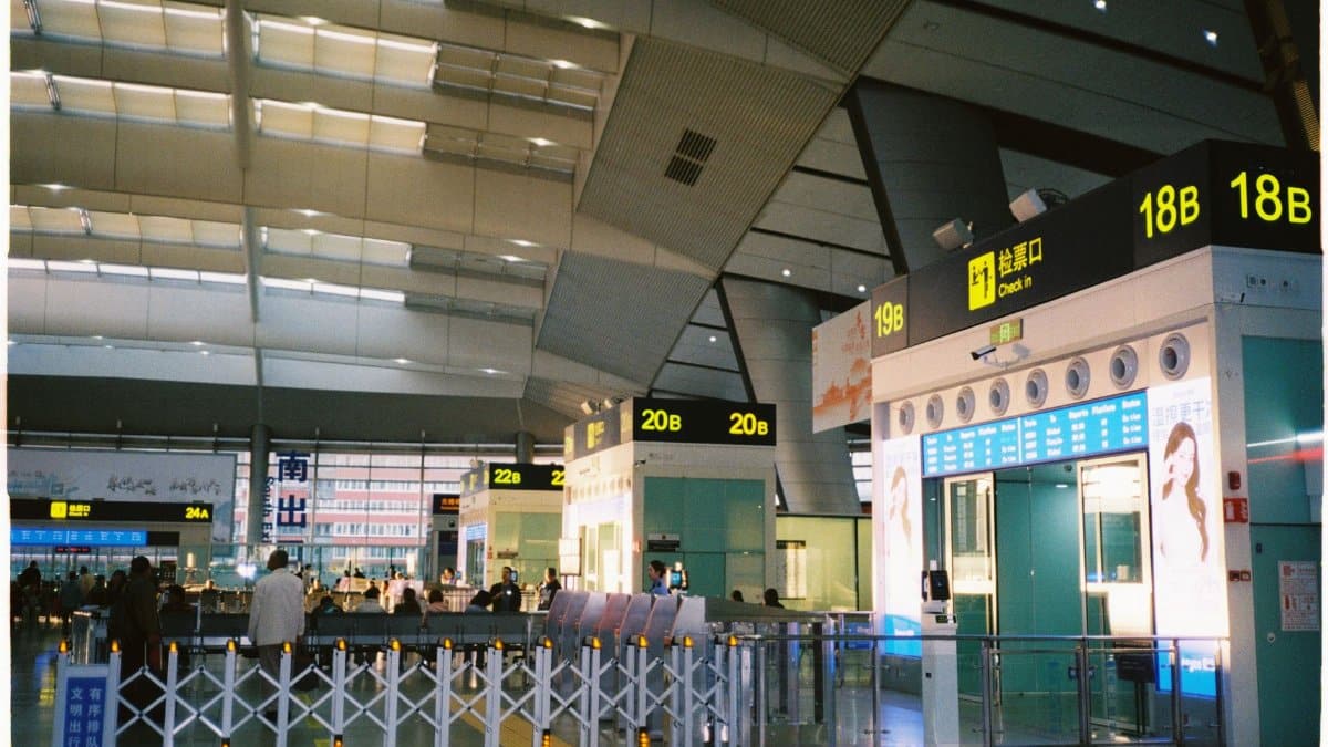 Spacious airport check-in area in China featuring bright signs and modern architecture.