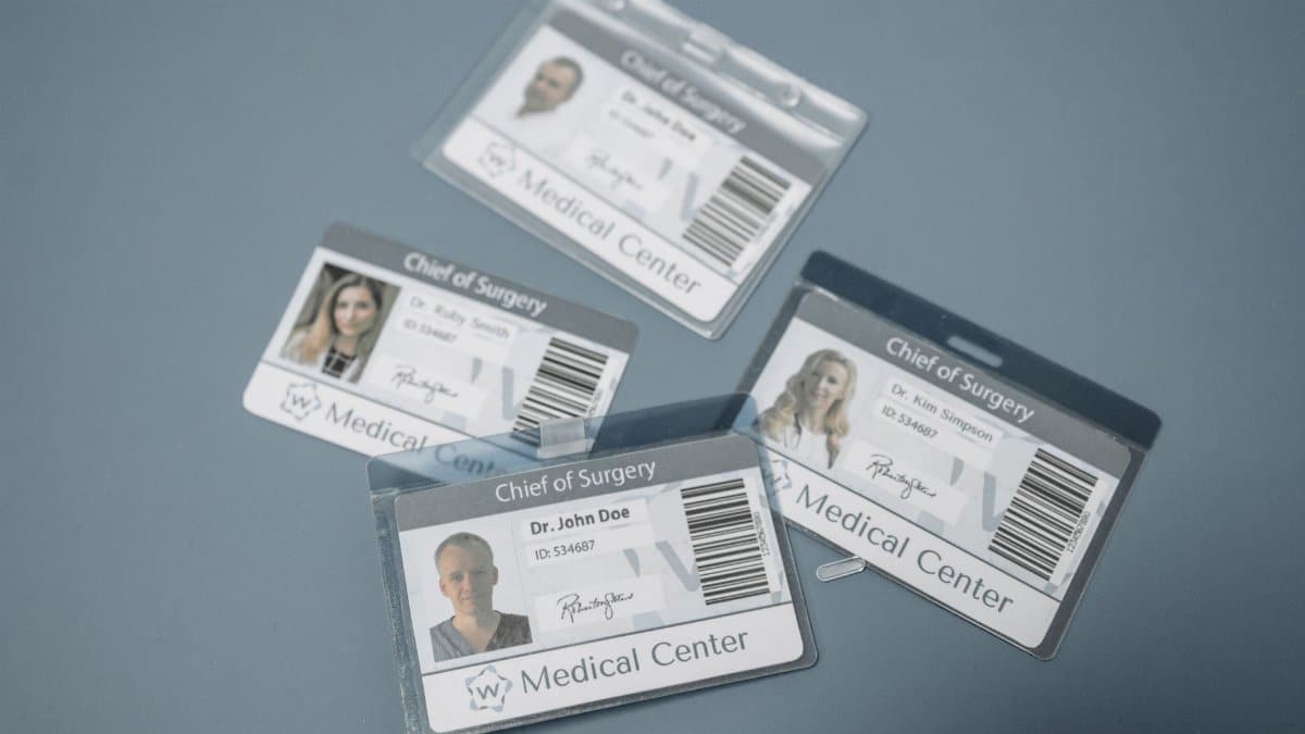 High-angle view of medical ID badges for chief surgeons on a gray surface.