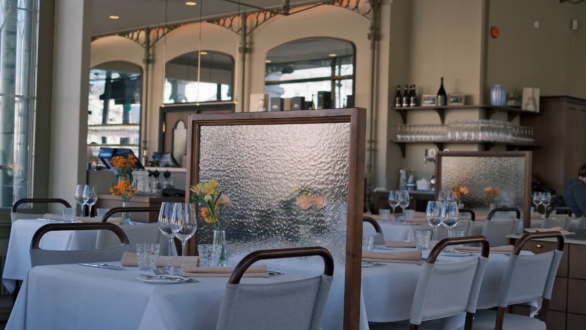 Elegant dining room with tables separated by decorative dividers for a cozy atmosphere.