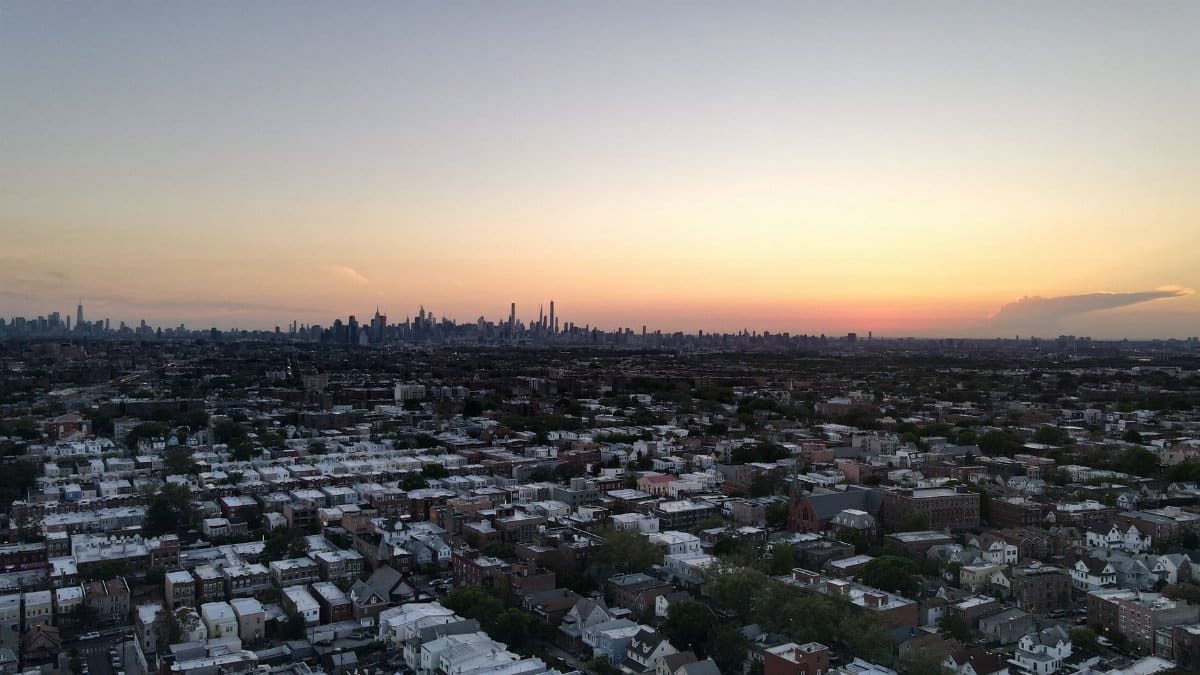 Aerial view of New York City skyline with a vibrant sunset backdrop.