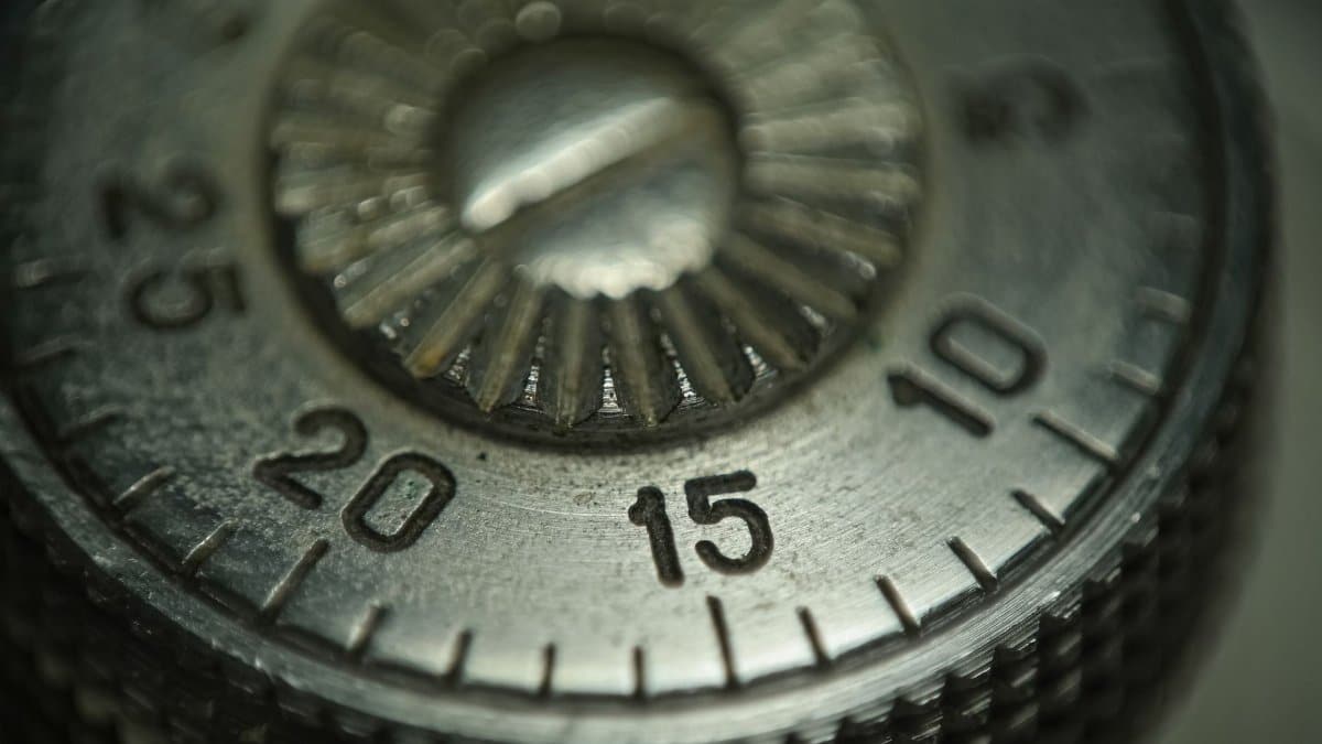 Detailed macro shot of a metallic combination lock dial showing numbers and texture.