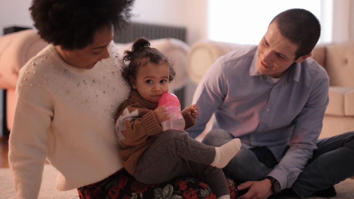 A joyful family bonding indoors with parents and a child sharing a happy moment together.