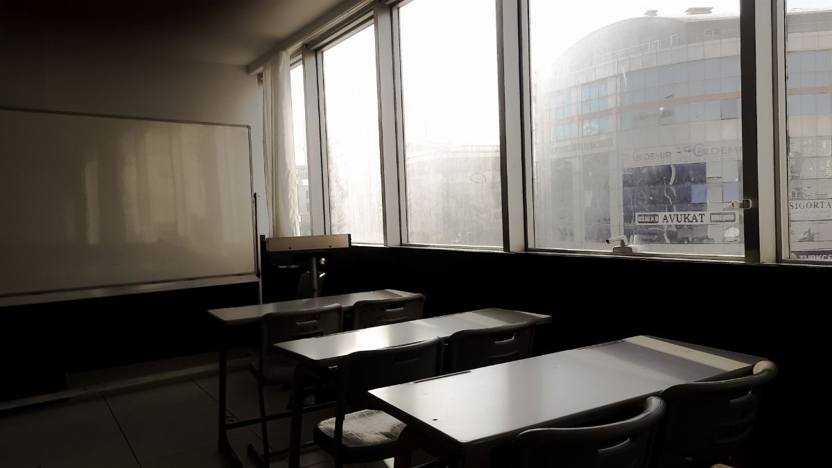 Sunlit empty classroom in Istanbul, featuring desks and a whiteboard.