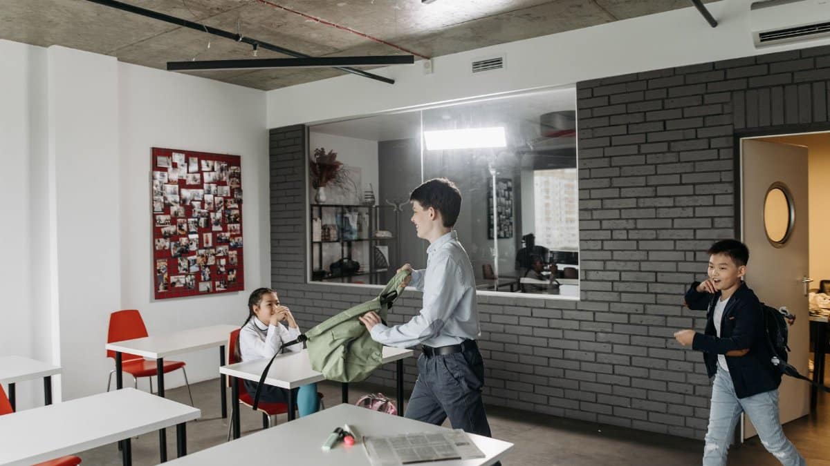 Children organizing backpacks and tasks in a modern classroom setting.