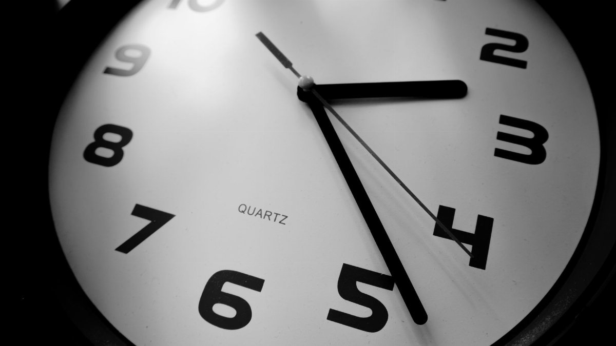 A detailed black and white close-up of a quartz clock emphasizing the numbers and time precision.