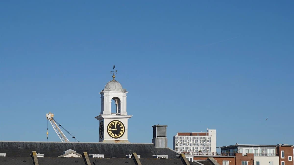 Scenic view of Portsmouth's iconic clock tower and cityscape under a clear blue sky.