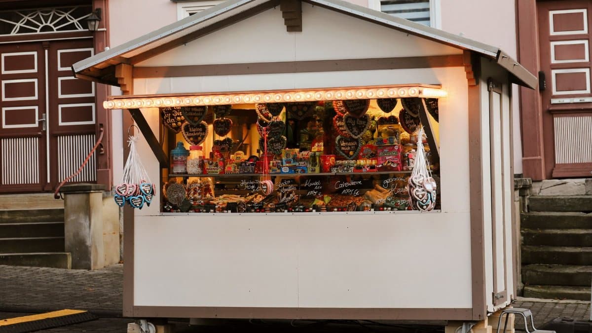 Festive Christmas market stall selling candies and treats at dusk.