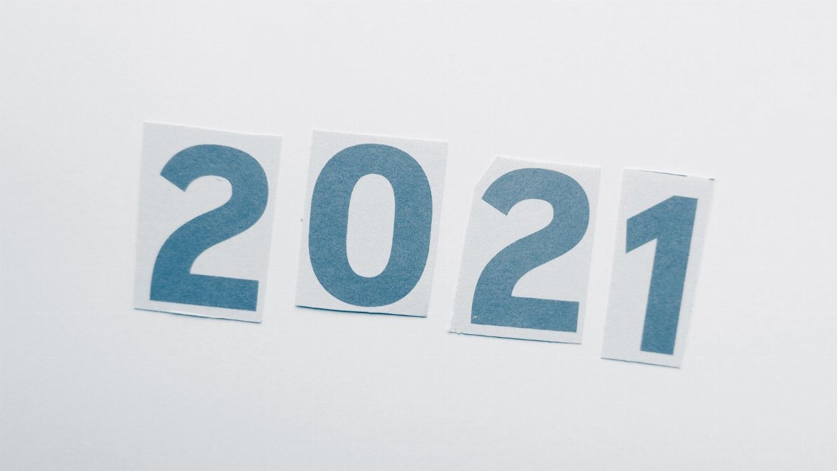 Simple paper cutout showing the year 2021 on a plain background.