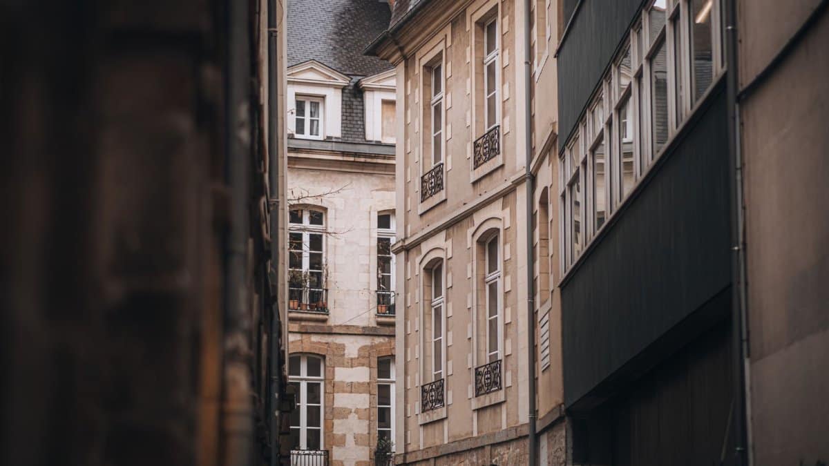 Explore the quaint architecture of a historic European city through this narrow alley view.