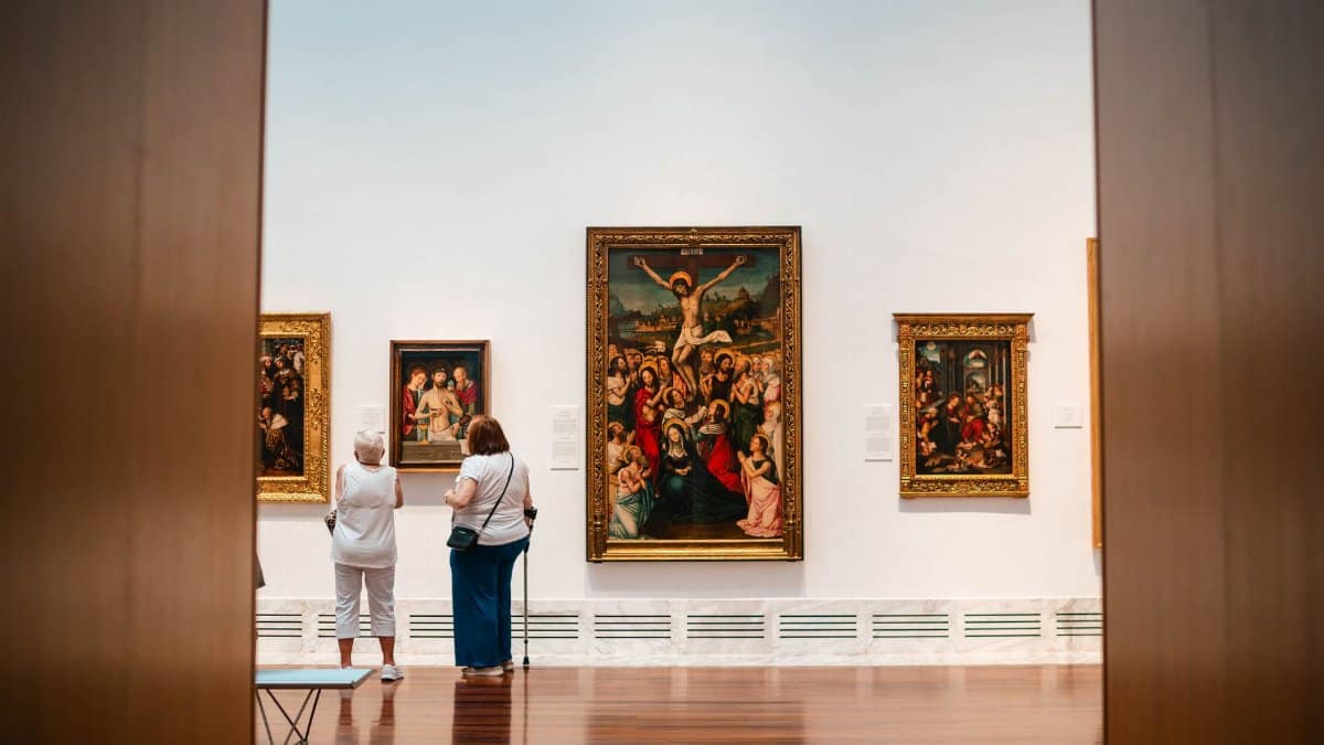 Visitors explore fine art paintings in a València gallery, capturing cultural appreciation.