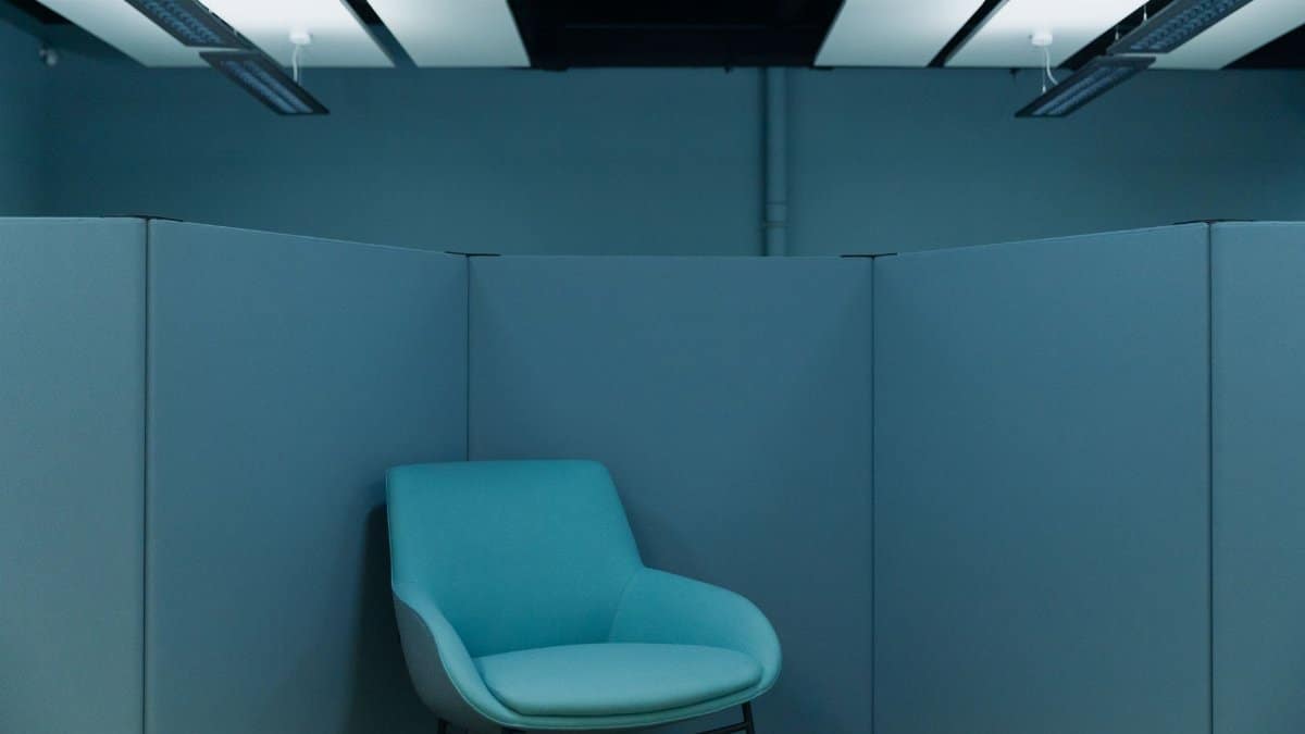 A serene office space featuring a stylish blue chair in a minimalist environment.