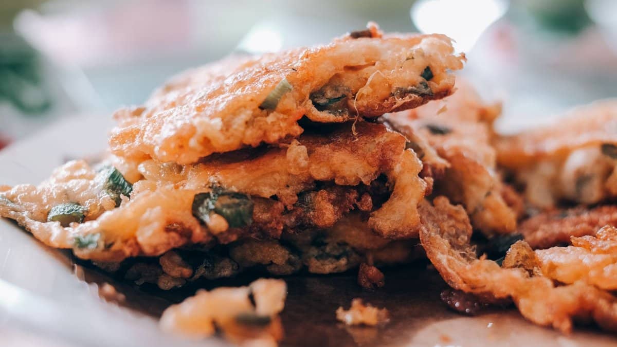 Delicious fried vegetable fritters stacked on a plate, perfect for food lovers.