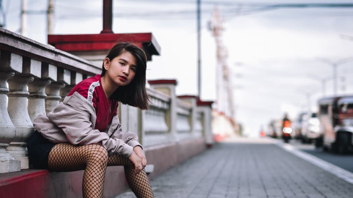 Stylish fashion model in urban street setting, showcasing modern streetwear style.