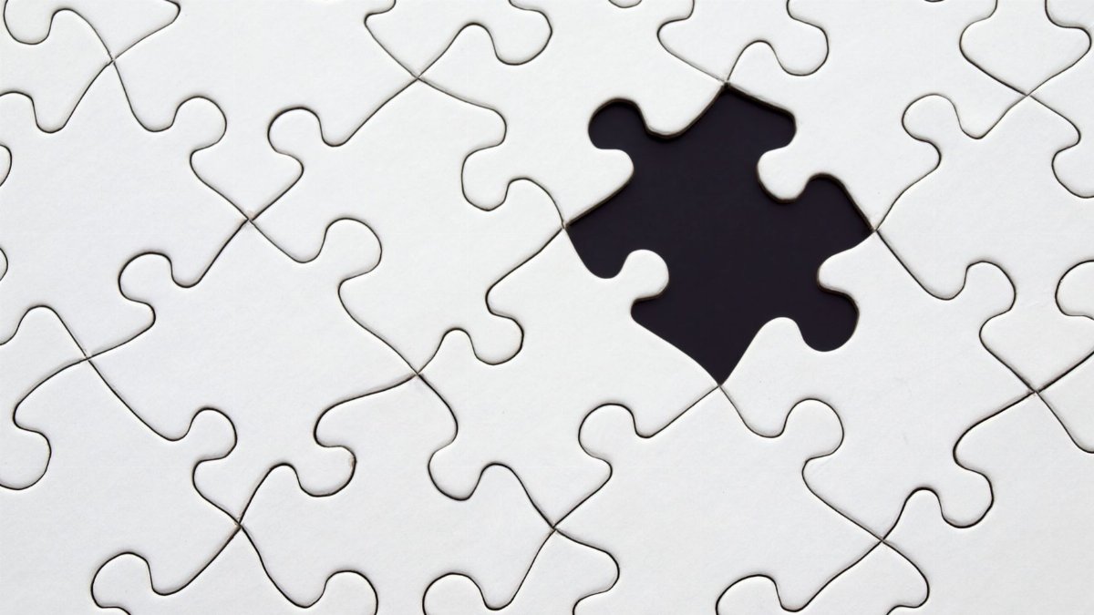 Close-up of an incomplete white puzzle with one missing piece, symbolizing challenge and strategy.