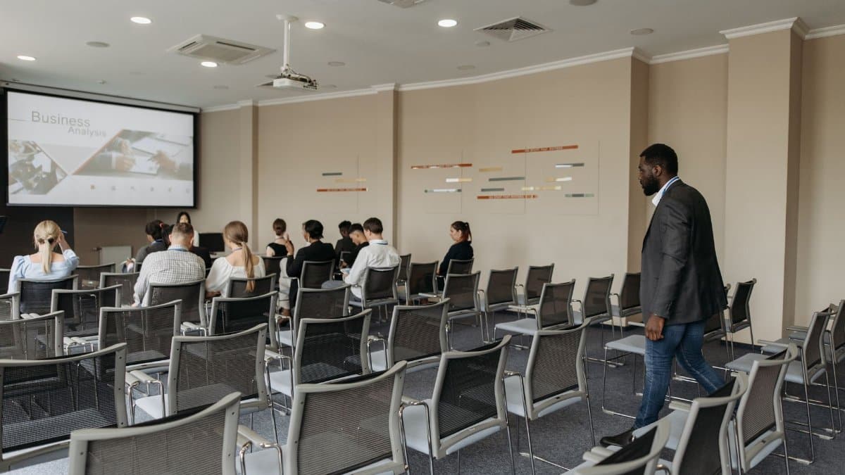 Attendees participate in a business analysis presentation in a contemporary conference room.