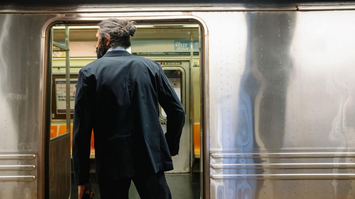 Back view of a businessman entering a subway train, symbolizing daily commute.