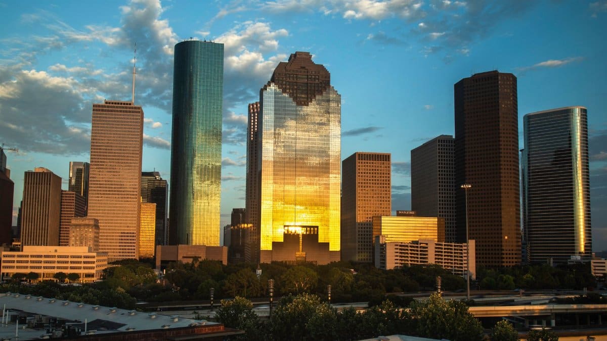 View of Houston's downtown skyline with a beautiful sunset reflection on skyscrapers.