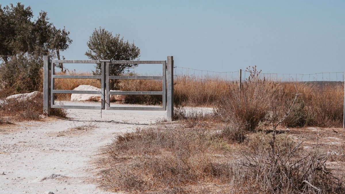 A rustic wooden gate in a serene countryside setting at Beit Guvrin, Israel.