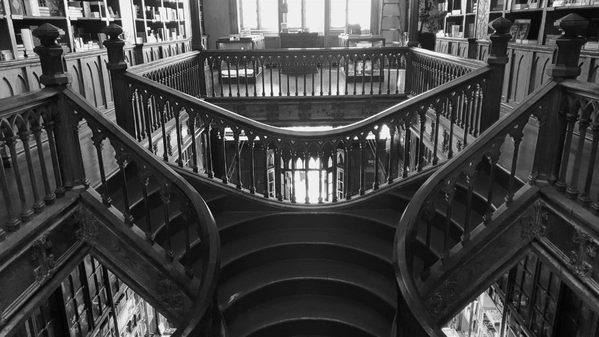 Intricate wooden staircase in a historic Porto library, showcasing timeless architecture.