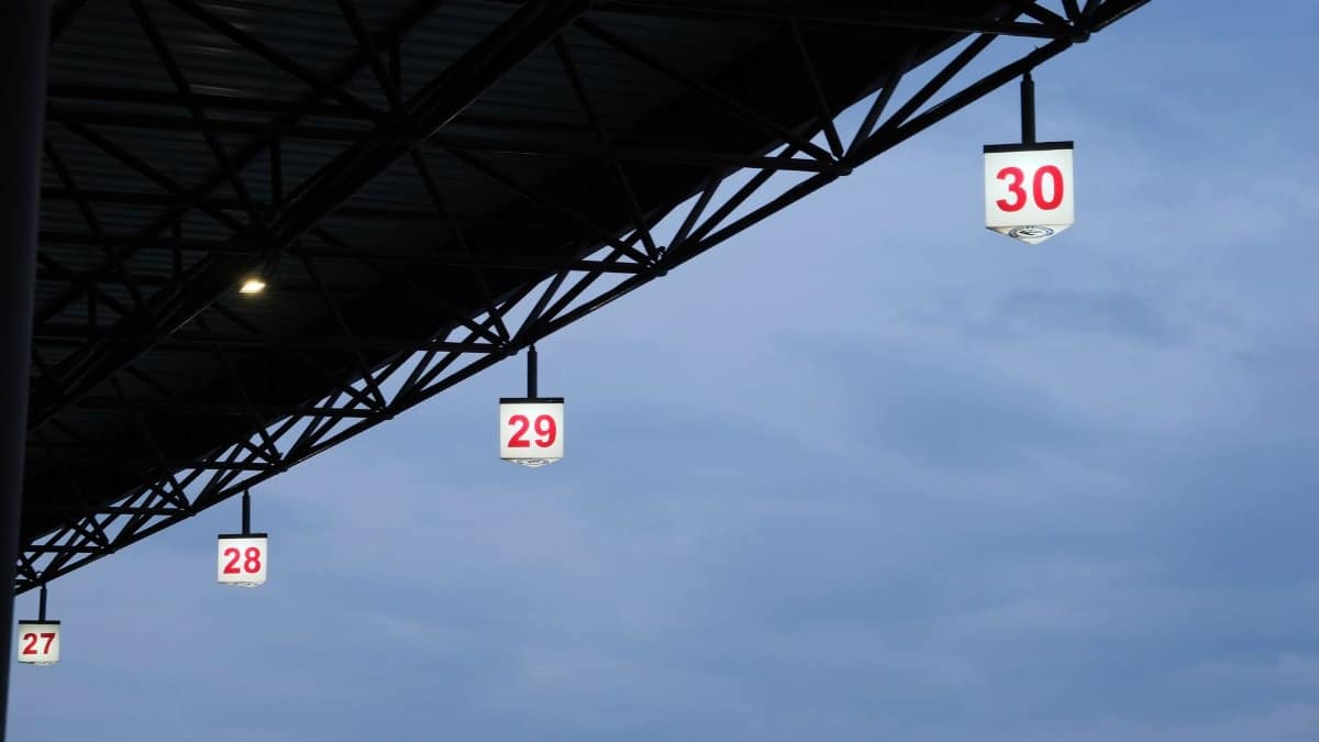 Numbered overhead lights in an outdoor platform setting with a clear sky backdrop.
