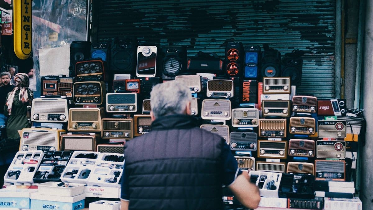 A bustling urban street market stall featuring a collection of vintage radios and electronics.