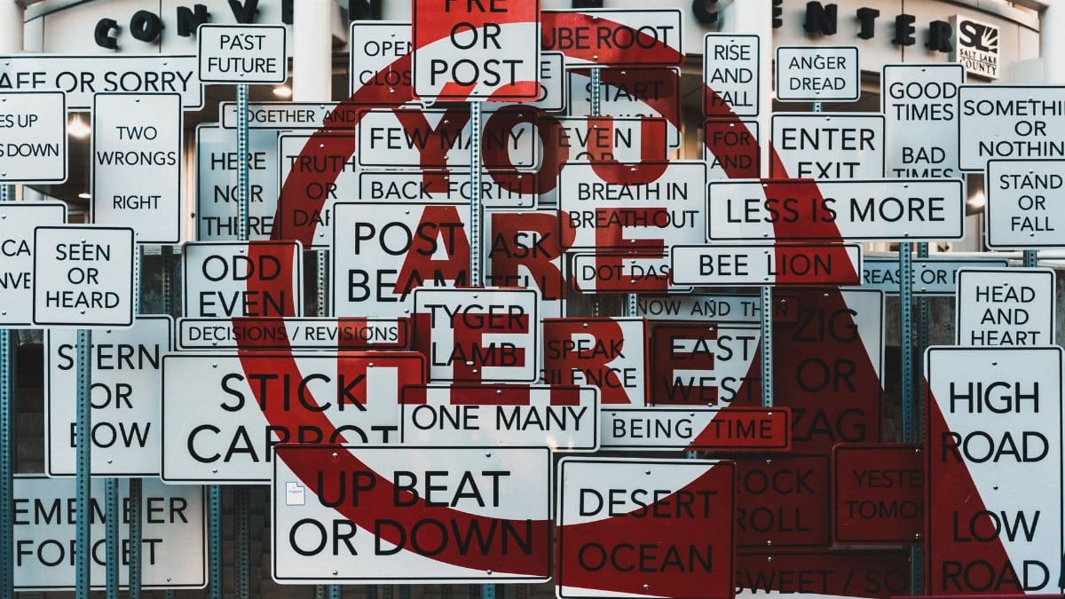 A creative collage of mixed message signs at the Salt Lake City Convention Center.