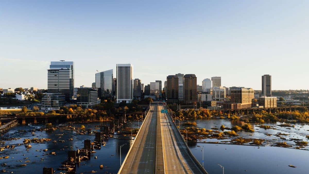 Stunning aerial shot of Richmond, Virginia skyline and bridge over water in daylight.