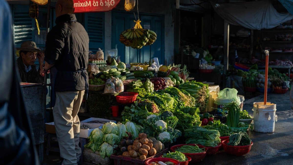 Street market in Dalat, Vietnam with fresh vegetables and early morning shoppers.