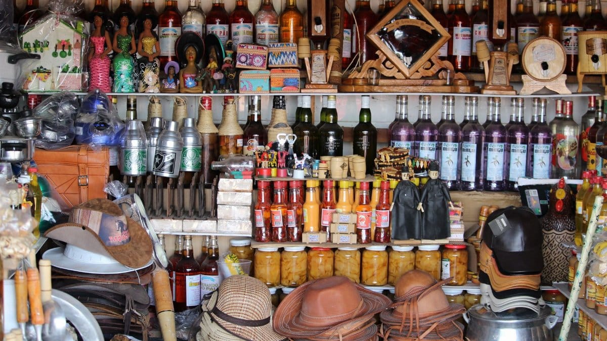 Vibrant market stand in Tianguá, Brazil showcasing local crafts and bottles.