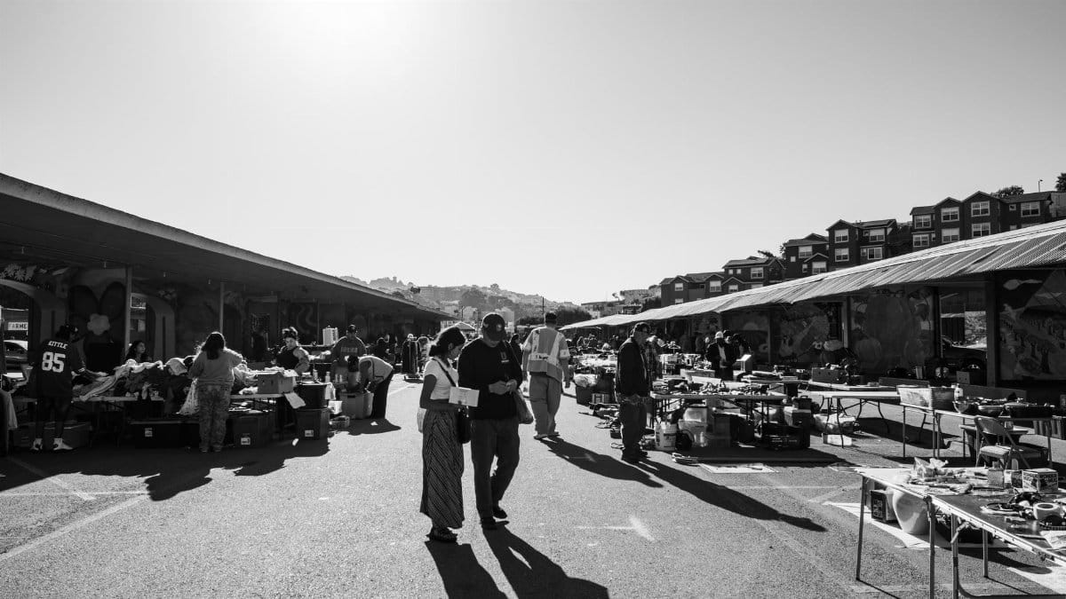 Black and white scene of Alemany Flea Market with shoppers and stalls in San Francisco.