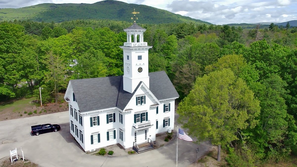Aerial view of Effingham Town Hall surrounded by lush greenery in New Hampshire.