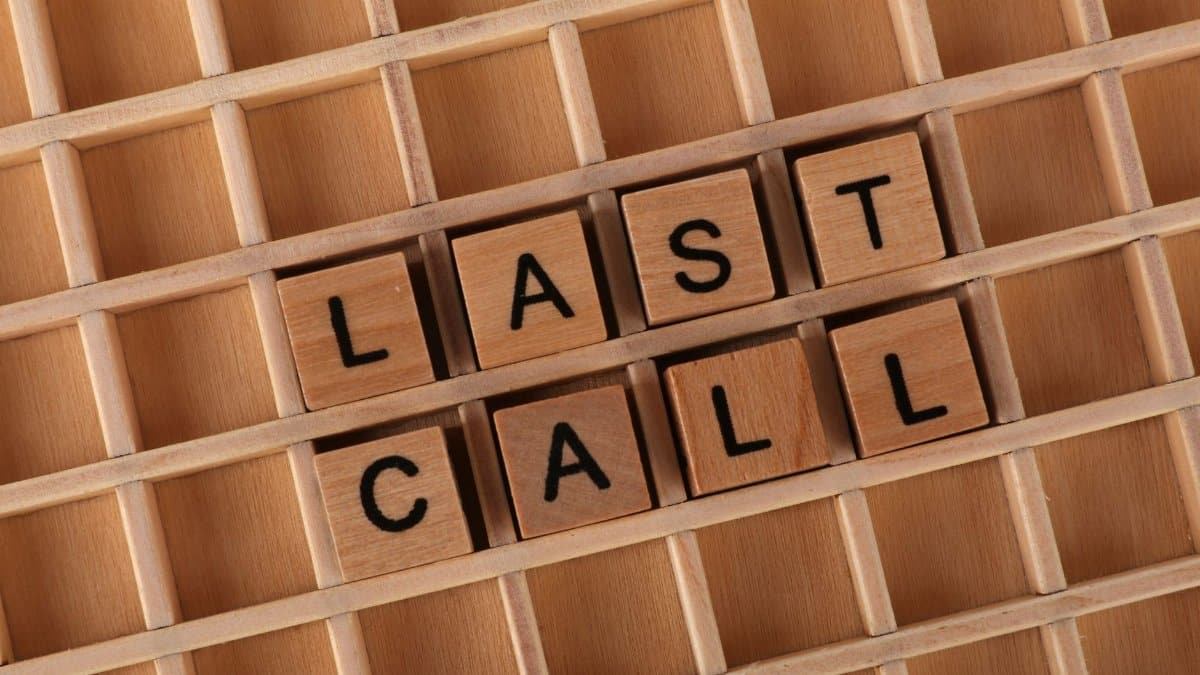 Wooden Scrabble tiles spelling 'Last Call' on a wooden grid background.