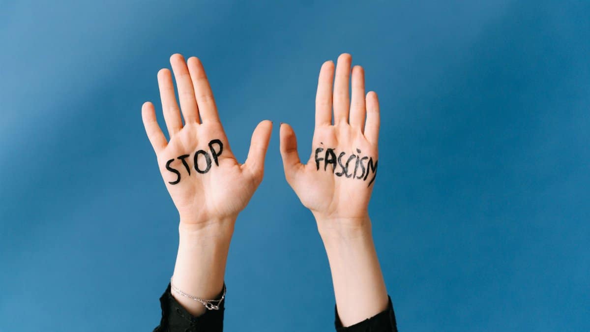 Hands raised against fascism with powerful message on blue background.