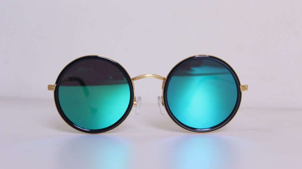 Elegant round sunglasses with blue-tinted lenses and gold frames, perfect for a trendy fashion statement.