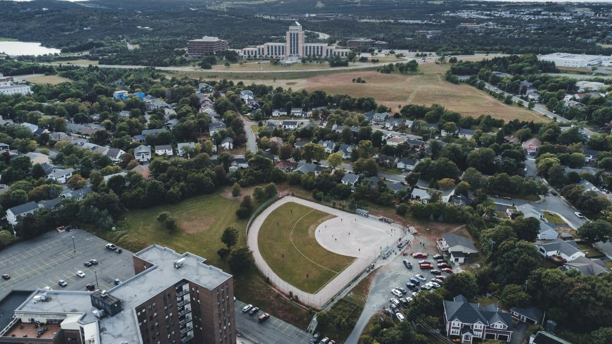 Aerial shot of a cityscape with buildings, park, and open fields, showcasing urban planning.
