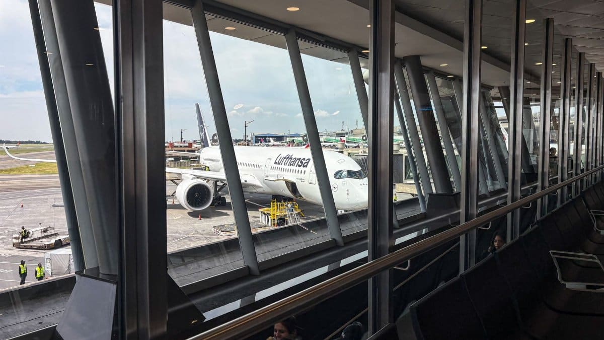 View of a passenger jet at an airport gate ready for boarding through terminal windows.
