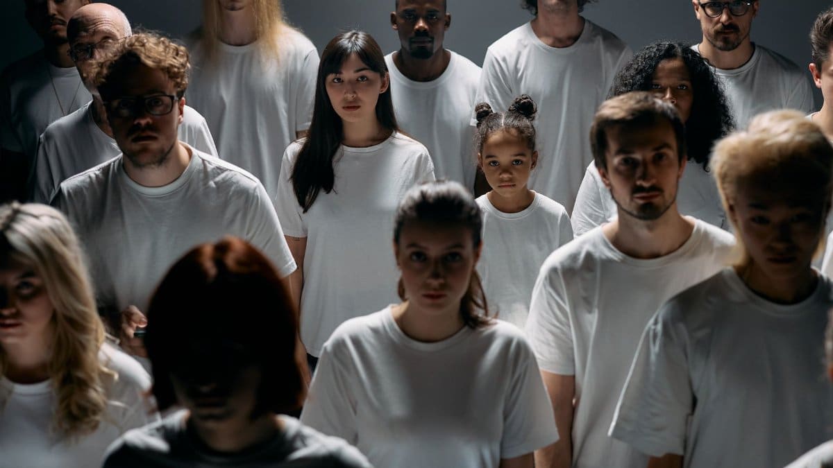A diverse group of people standing together, emphasizing individuality and unity in a minimalist setting.