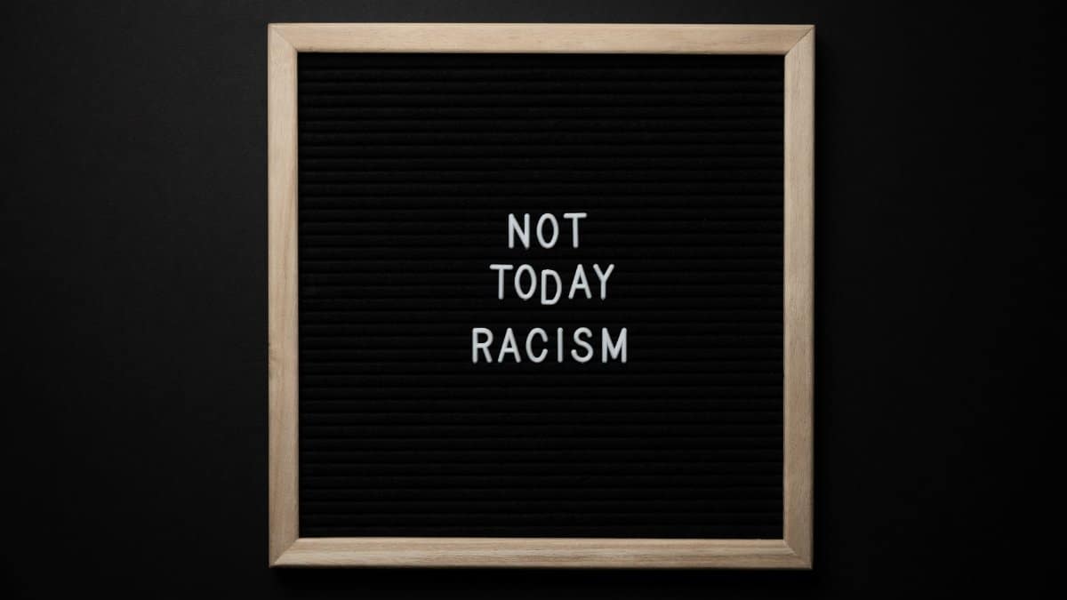 Overhead view of phrase Not Today Racism on square framed signboard on black background