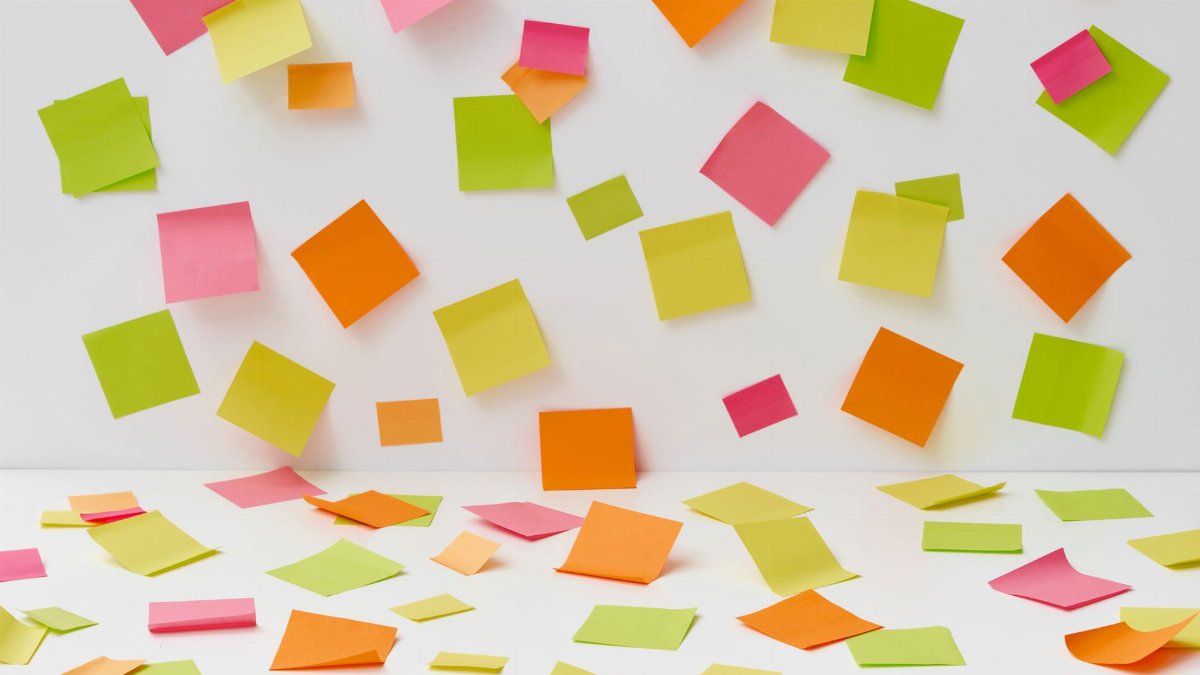 Vibrant sticky notes scattered on a white surface, perfect for organizational themes.