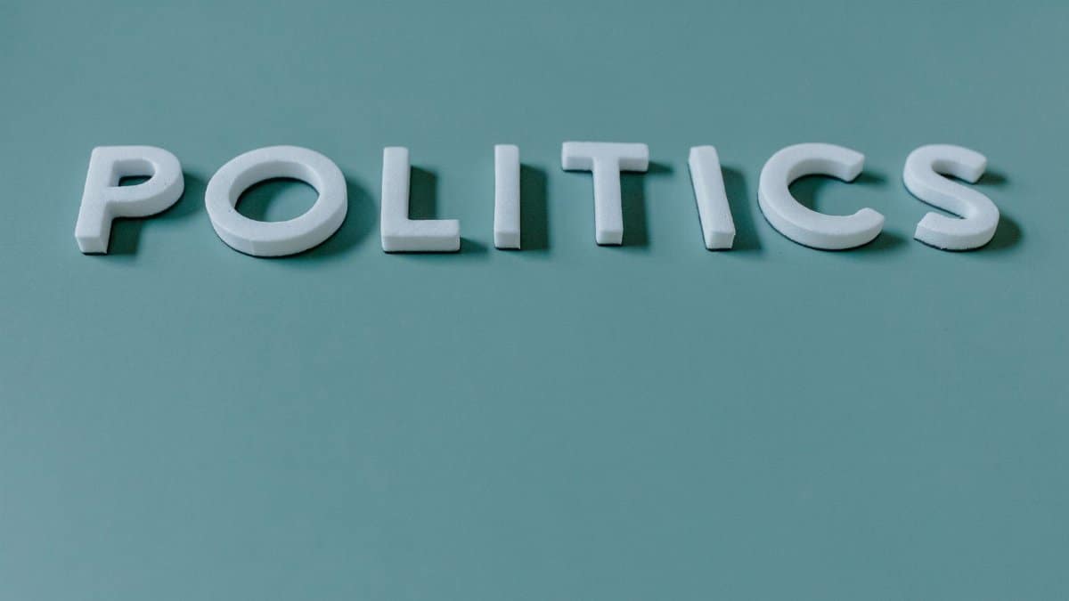 Close-up image of the word 'Politics' against a teal green background, highlighting political themes.