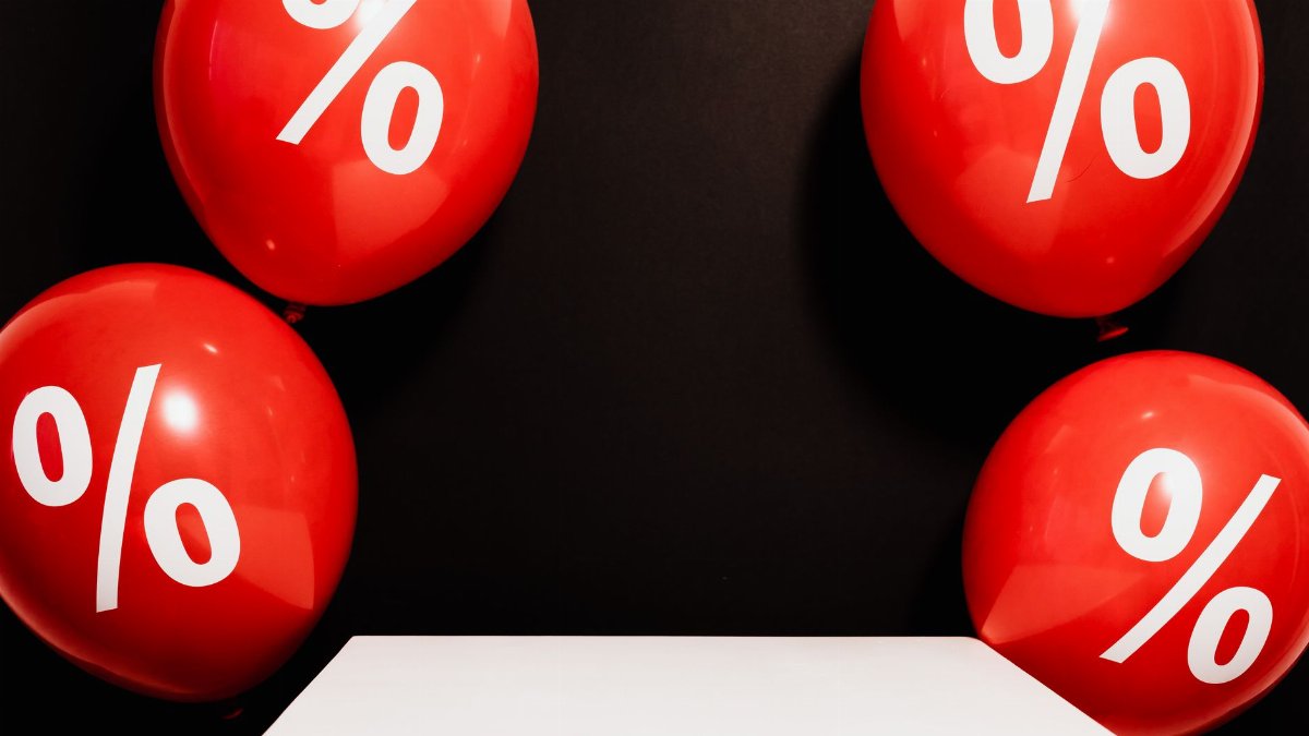 Red balloons marked with percentage symbols on black background, perfect for sales promotions.