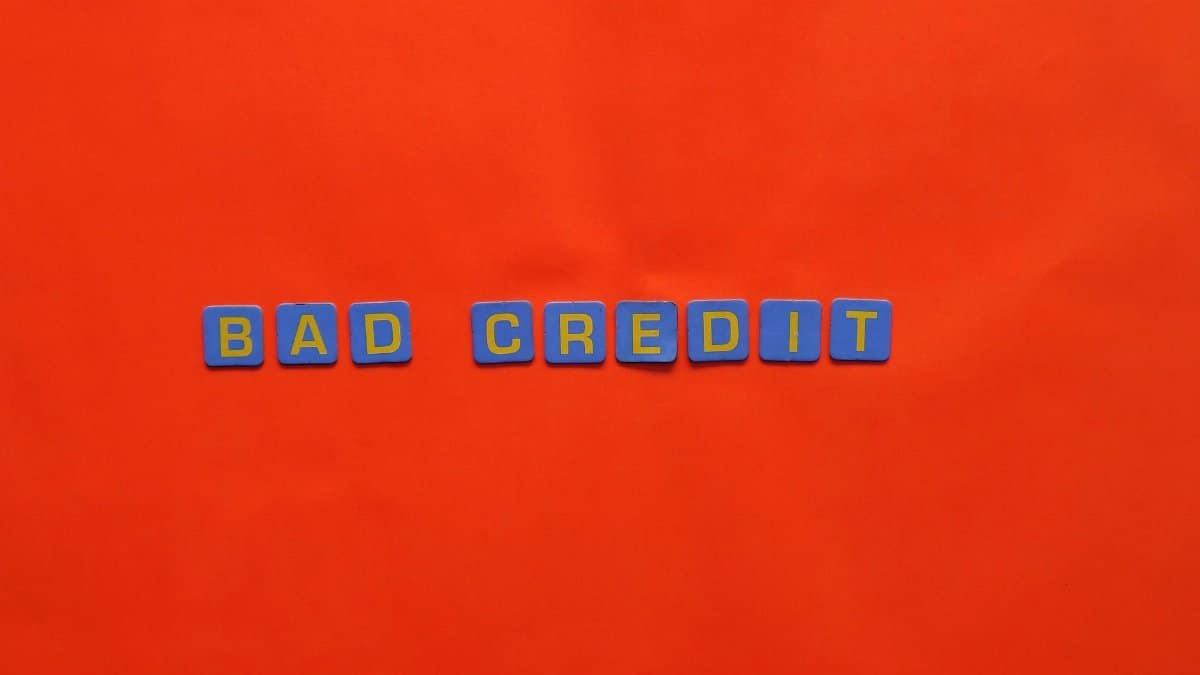 Blue letter blocks spelling 'Bad Credit' on an orange background.