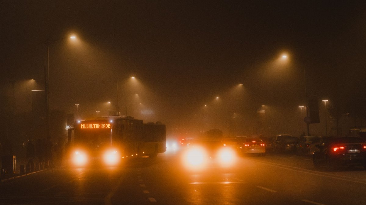 Foggy night view of vehicles and streetlights on a busy Istanbul road, creating a moody atmosphere.