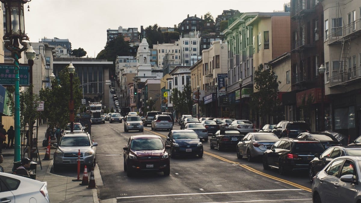 A bustling urban street scene with cars and buildings, depicting vibrant city life.