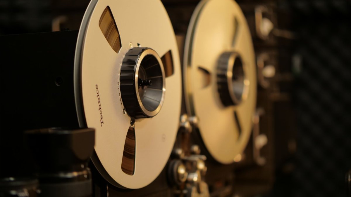Close-up of a vintage reel-to-reel tape recorder in a professional audio recording studio.