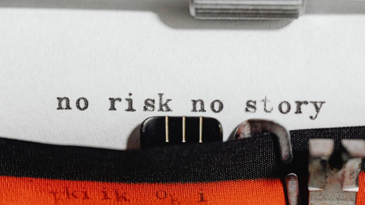Close-up of a vintage typewriter typing 'no risk no story' on paper.